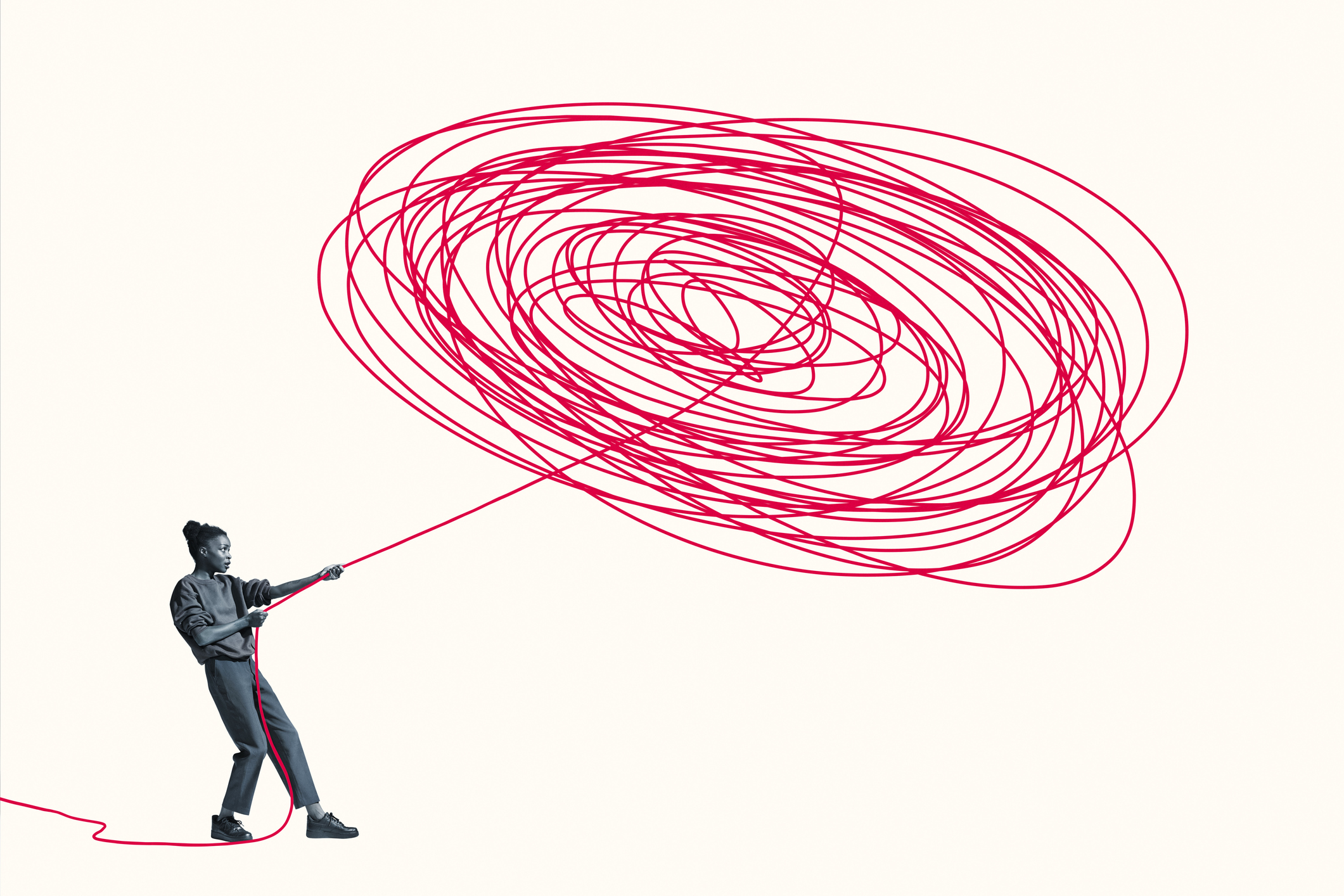 Full length of woman pulling vibrant red rope from tangle pattern against white background