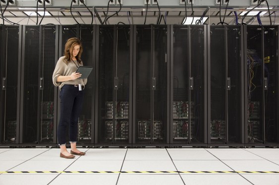 Mixed race businesswoman using tablet computer in server room