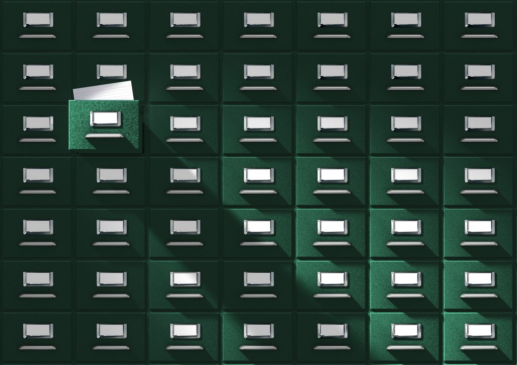 An immense card catalog system with one drawer pulled out.
