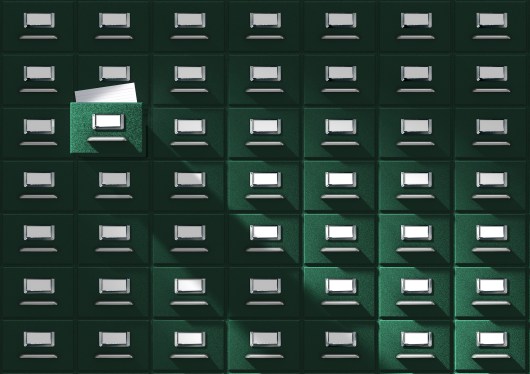 An immense card catalog system with one drawer pulled out.