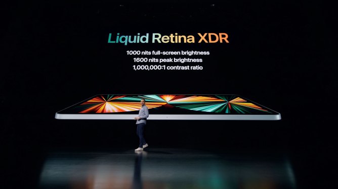 presenter in front of screen with iPad Pro 2021, text reads Liquid Retina XDR, 1000 nits full-screen brightness, 1600 nits peak brightness, 1,000,000:1 contrast ratio
