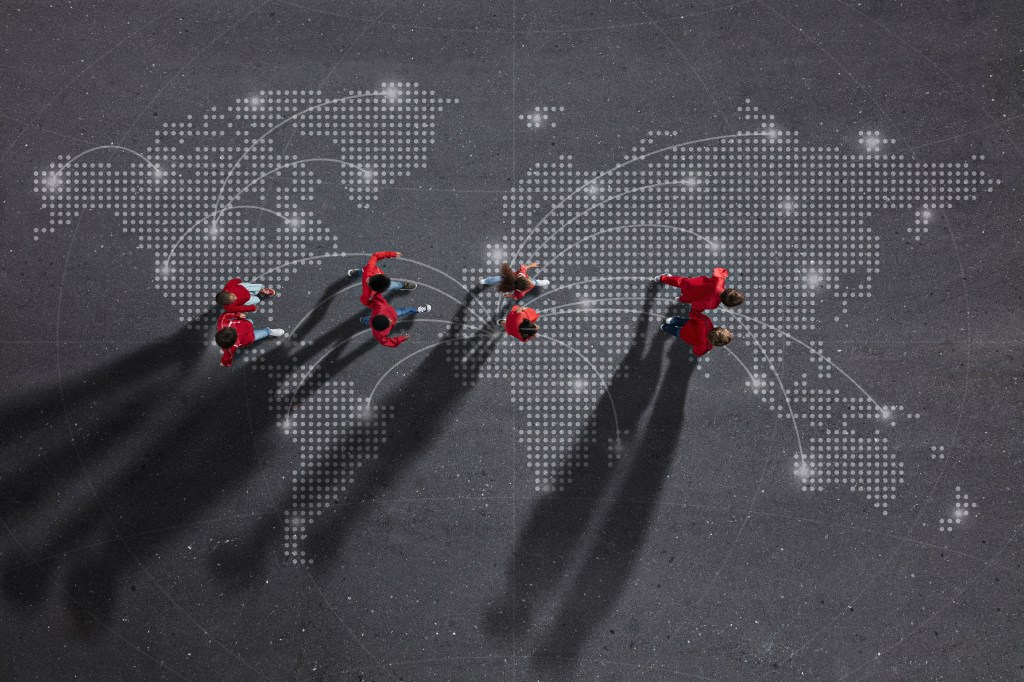 Image of four pairs of individuals walking over a map of the world with interconnected points to represent the global impact of investing in diverse founders and companies.