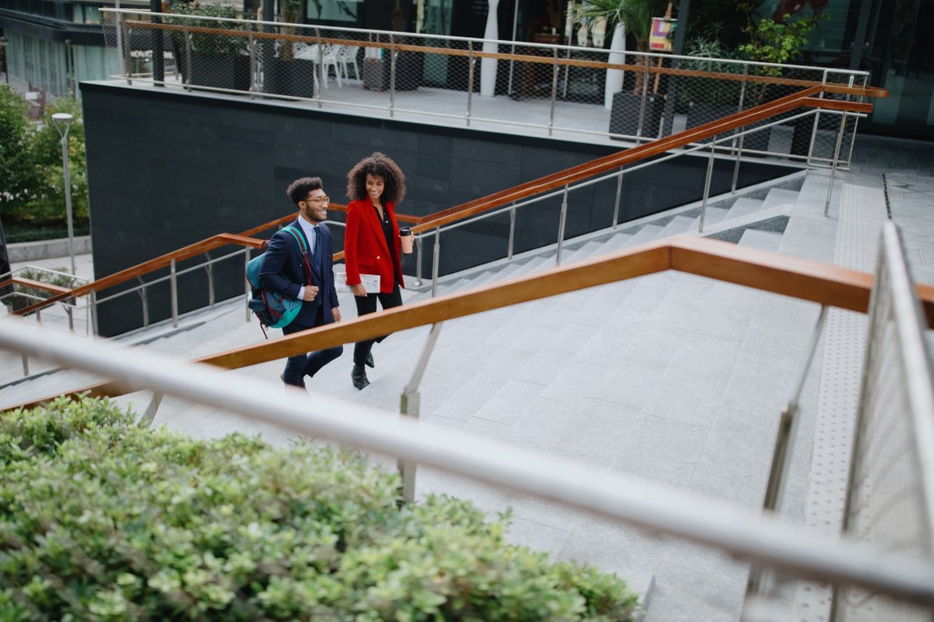 Two coworkers climbing up the stairs