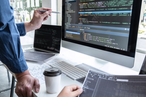 Midsection Of Engineers Coding In Office