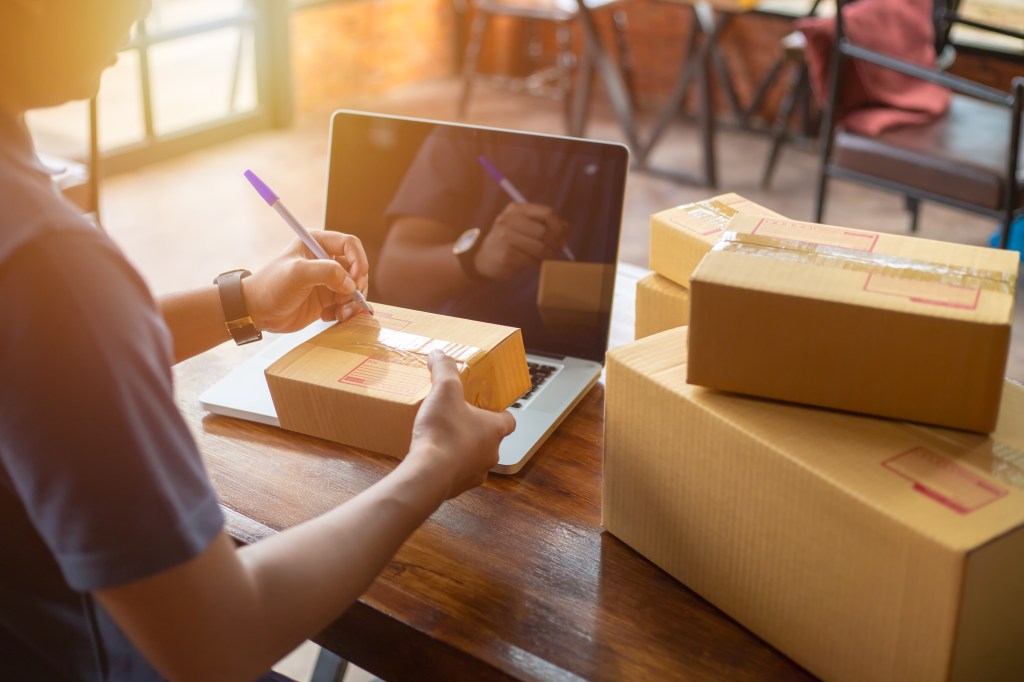 Online shopping young start small business in a cardboard box at work. The seller prepares the delivery box for the customer, online sales, or ecommerce.