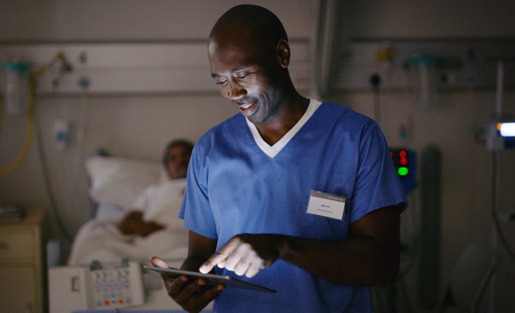 Medical practitioner using a digital tablet in a hospital ward