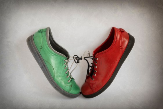 A red and a green shoe tied together