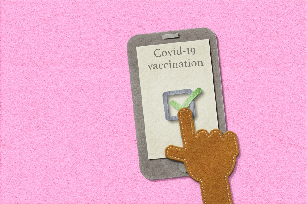 Hand pointing to smartphone with proof of vaccination.