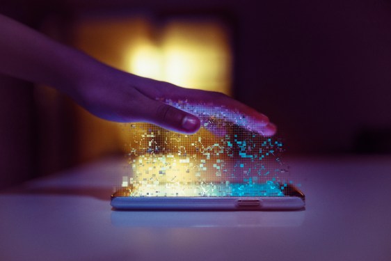 Hand pulling different colored lights out of a tablet, meant to symbolize data flowing.