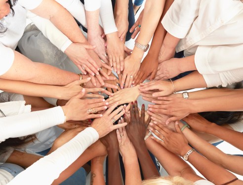Hand of diverse women huddling