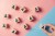 Image of wooden blocks with people on them on a pink and blue background to represent gaining more users via accessibility.