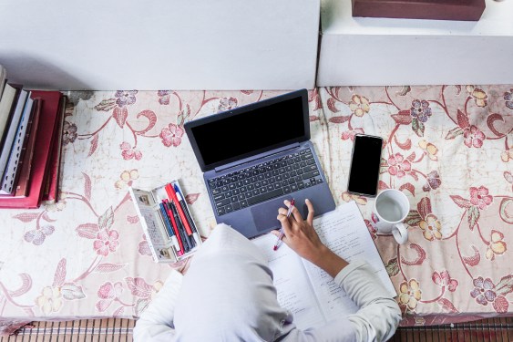 Girl using laptop during homework at living room