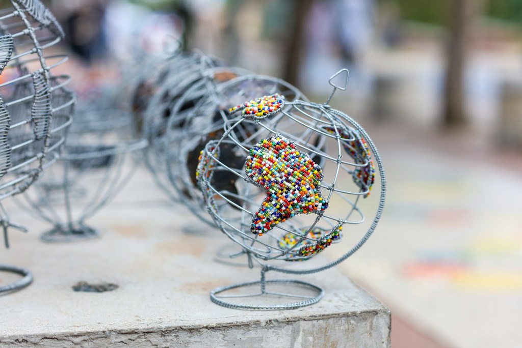 Image of a metallic globe with Africa made up of little beads.