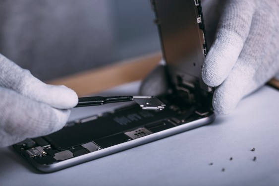 Detail image of technician repairing smart phone at electronics store