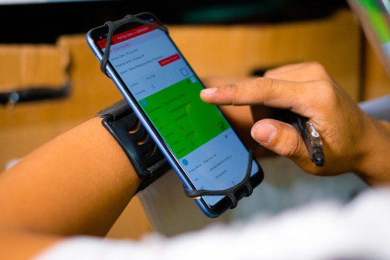 Locad's app displayed on a smartphone being used by a warehouse worker