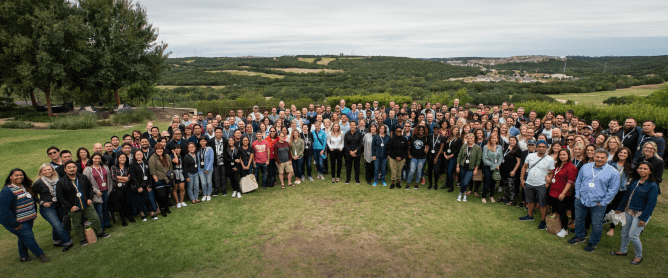 Articulate employee group picture on a mountain top overlooking a green valley