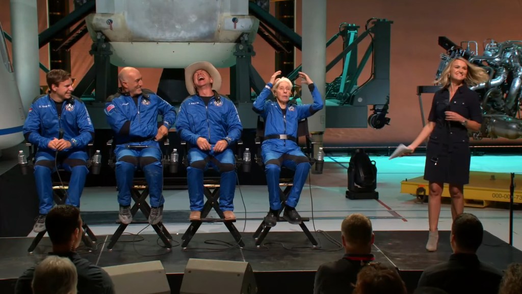 Blue Origin's first astronauts laugh on stage at a press conference after the launch.
