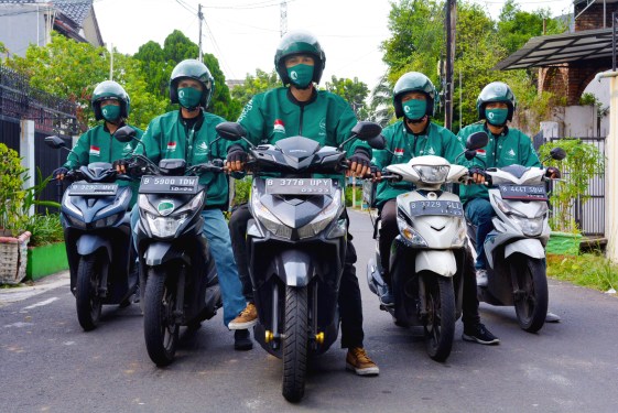 A group photo of RaRa Delivery drivers on scooters in Indonesia