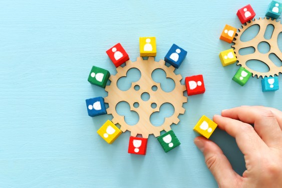 colorful blocks with people icons over wooden table