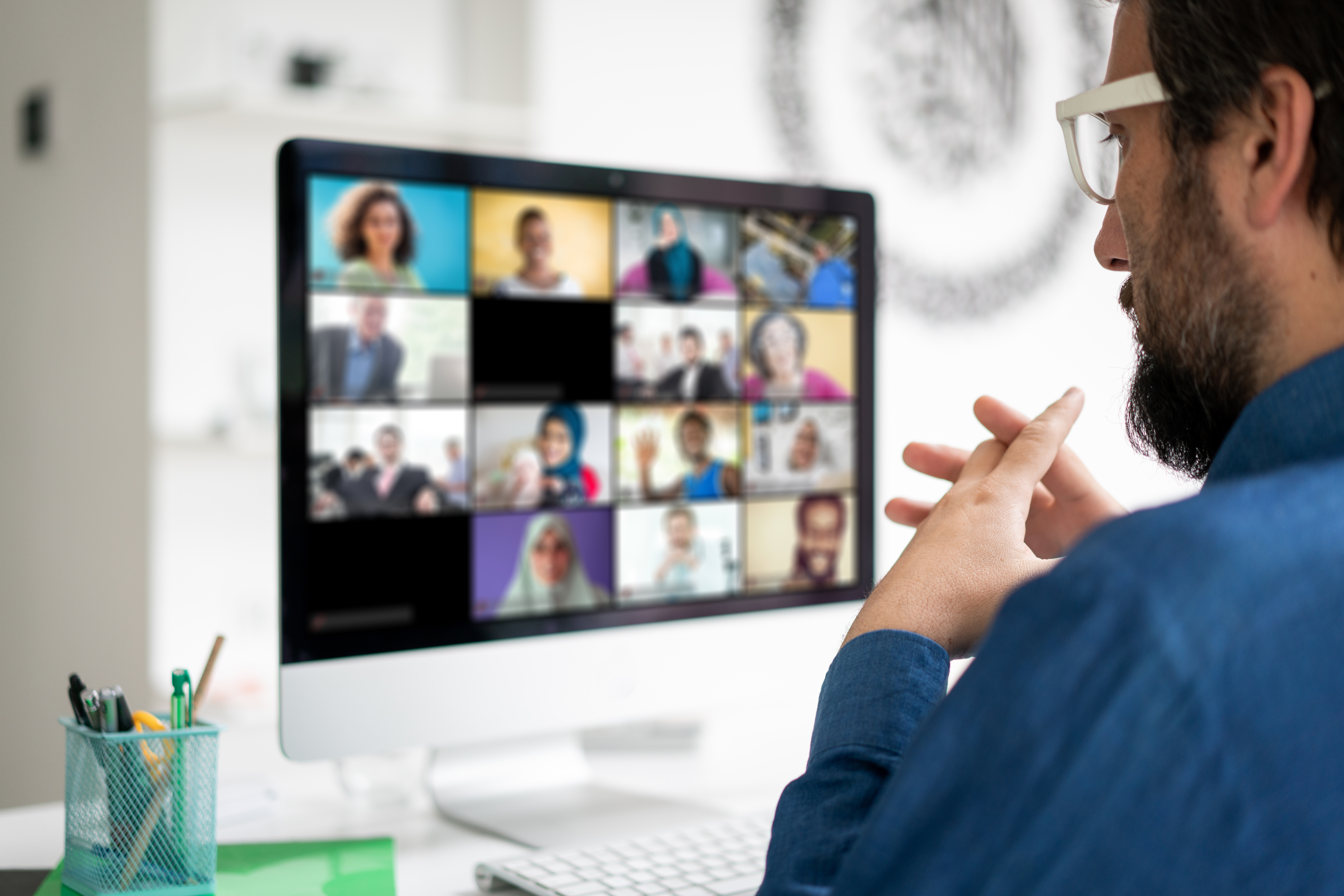 Image of a manager talking to his team via a video conference.