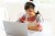 Student with headphones studying at a laptop