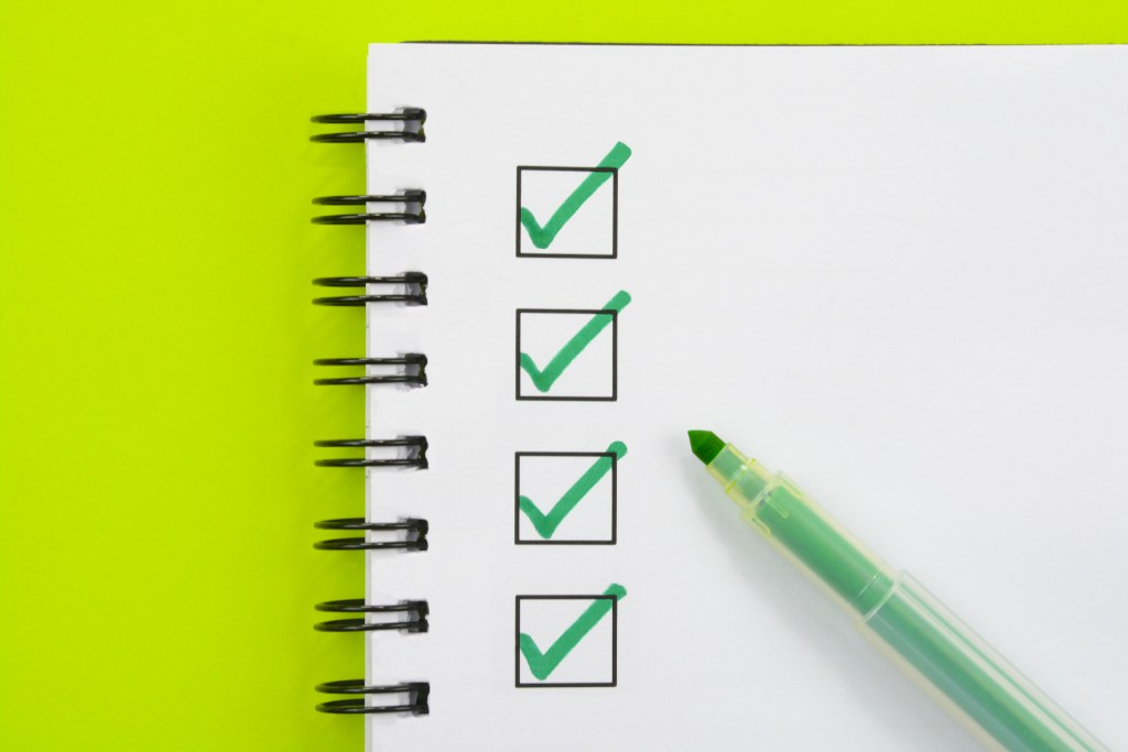 Image of green check marks on checked box with green pen.