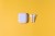 Trendy cordless white headphones on yellow background