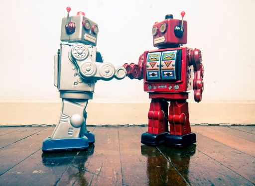 two vintage robot shake hands