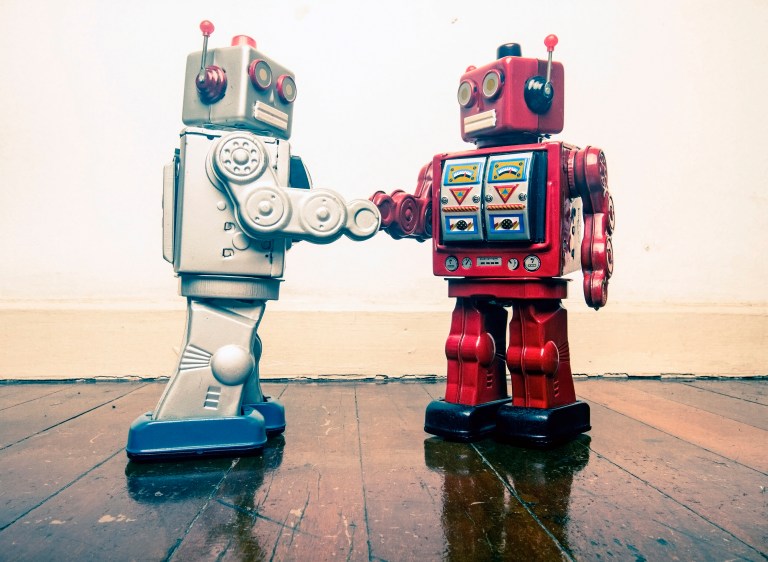 two vintage robot shake hands