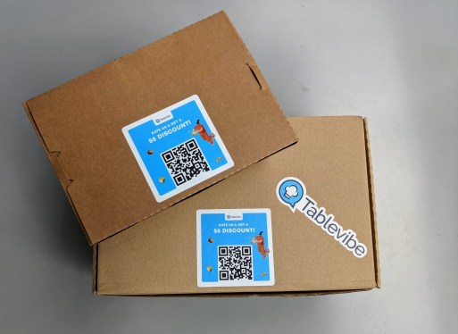 Takeout boxes with Tablevibe's QR code and logo stickers