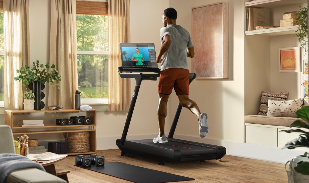 Peloton Tread, man running on the treadmill while watching workout video
