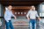 Blockchain startup co-founders Winston Hsiao and Wayne Huang in front of the company's logo