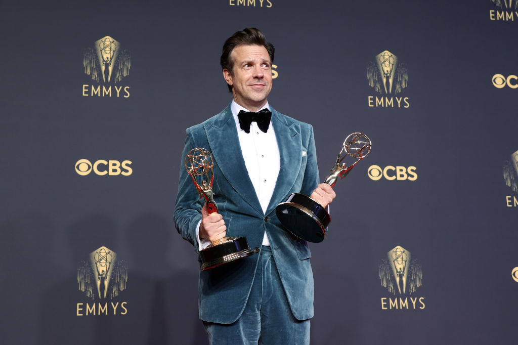 Jason Sudeikis holding 2 Emmy awards