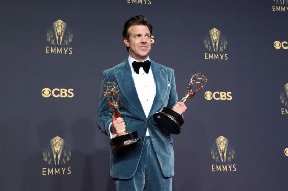 Jason Sudeikis holding 2 Emmy awards