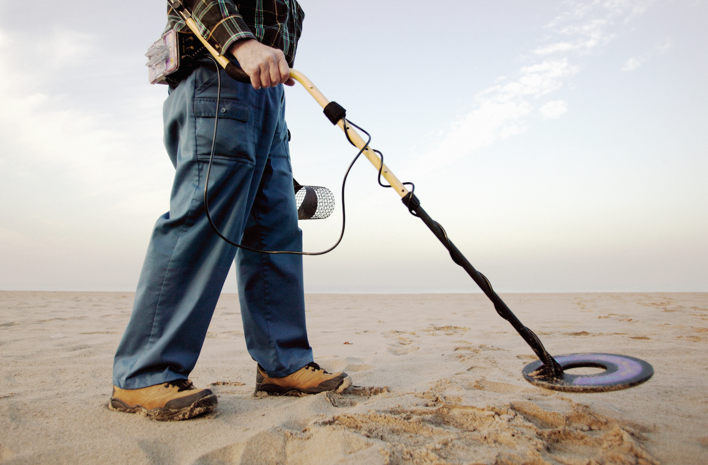 Man using metal detector at beach