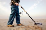 Man using metal detector at beach