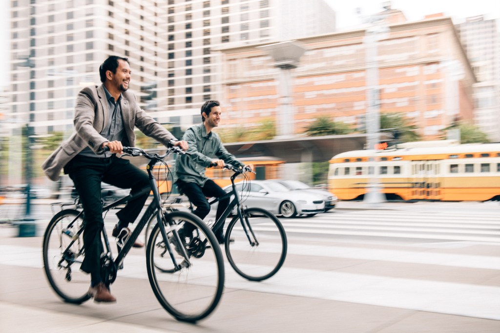 Two businessman have a meeting while riding bikes to work