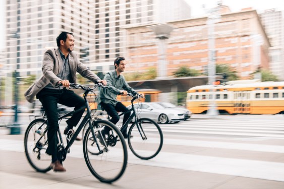 Two businessman have a meeting while riding bikes to work