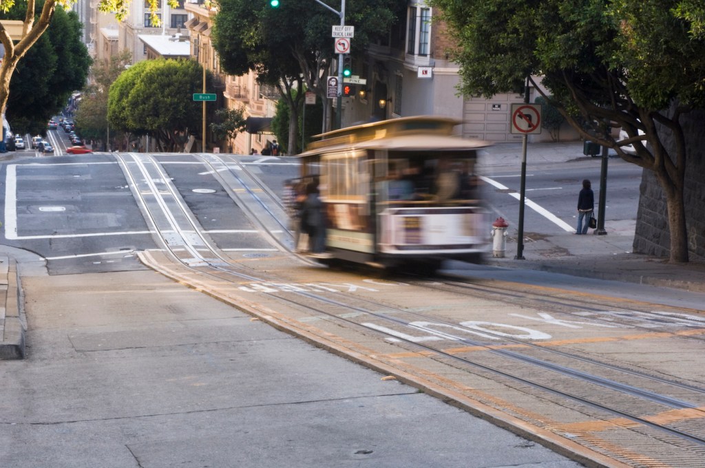 A blurred image of a cable car descending California Street in San Francisco's Nob Hill neighborhood.
