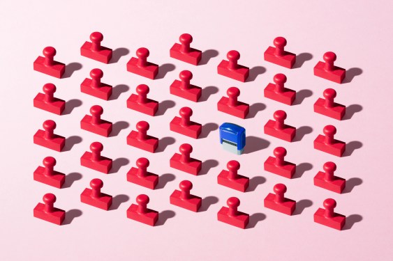Blue Colored Auto Stamp among Red Rubber Stamps on Pink Background.
