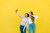 A young latinx girl and a brunette caucasian girl taking a selfie and posing together in front of a yellow background.