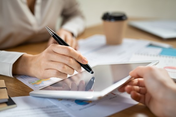 Close up of woman's hand signing a contract on digital tablet