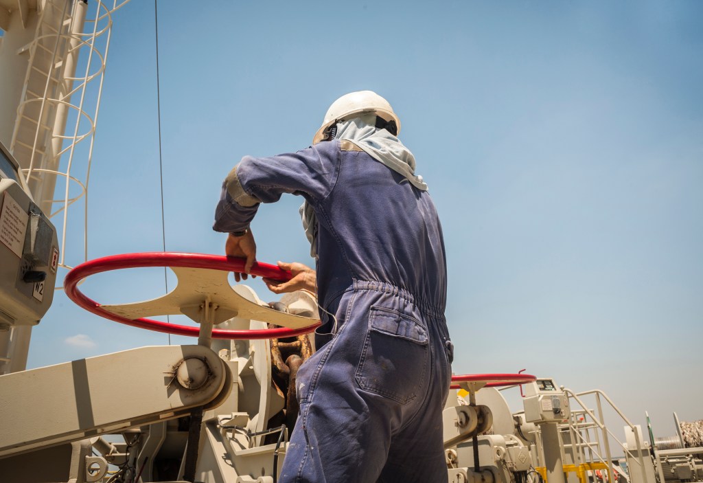 Filipino seafarer unblocking an anchor on a container ship, maritime industry