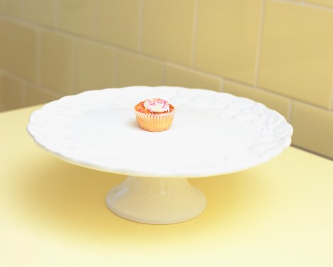A single cupcake at the center of a cake dish