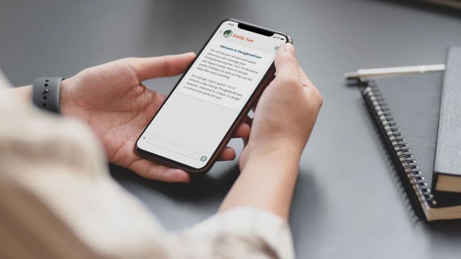 Close-up of a person's hands holding a smartphone with ThoughtFull's mental health app open