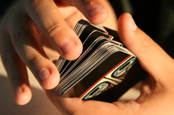 A pair of hands shuffling a deck of cards
