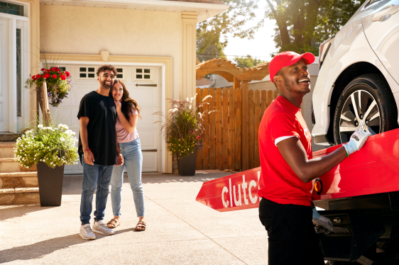 happy couple watch clutch worker onload car bought online and delivered to door