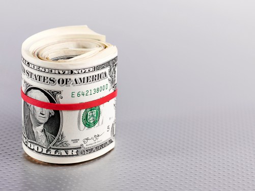 Roll of dollar bills bound with a red rubber band