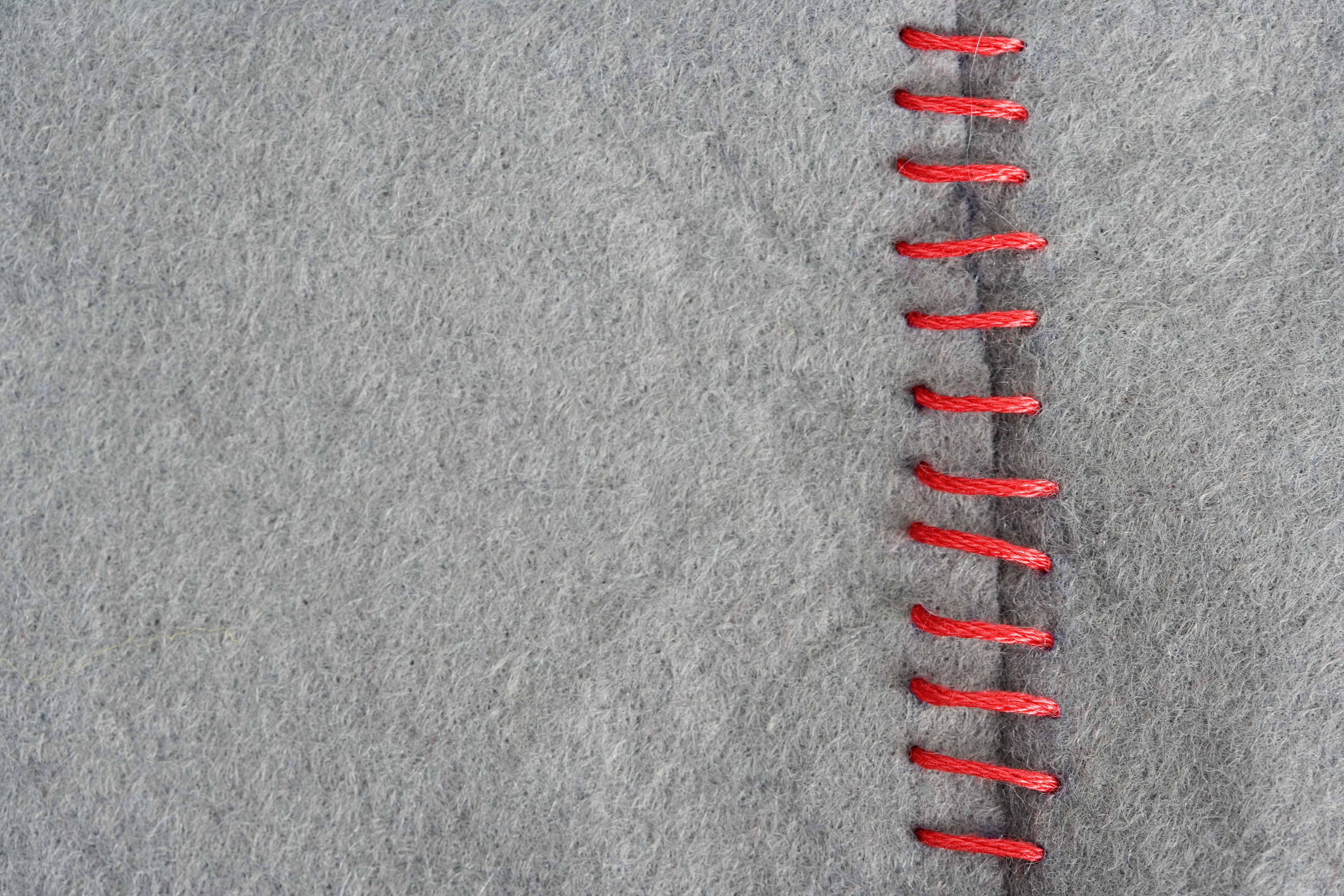 Red stitching on gray fabric