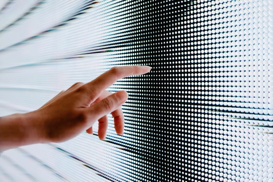 Closeup of woman's hand touching illuminated LED display screen to represent solving small data problems.